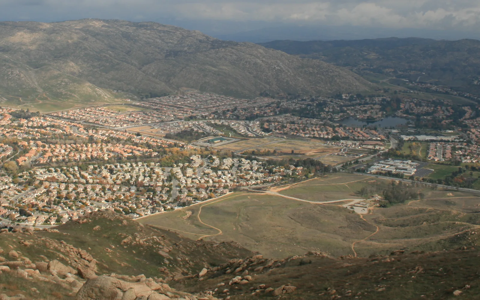 Wide view across Moreno Valley neighborhoods toward foothills beneath a pale blue sky